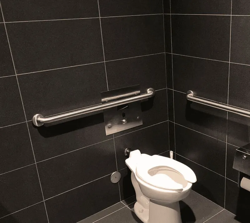 Brushed stainless grab bars installed on dark charcoal tile in a shower