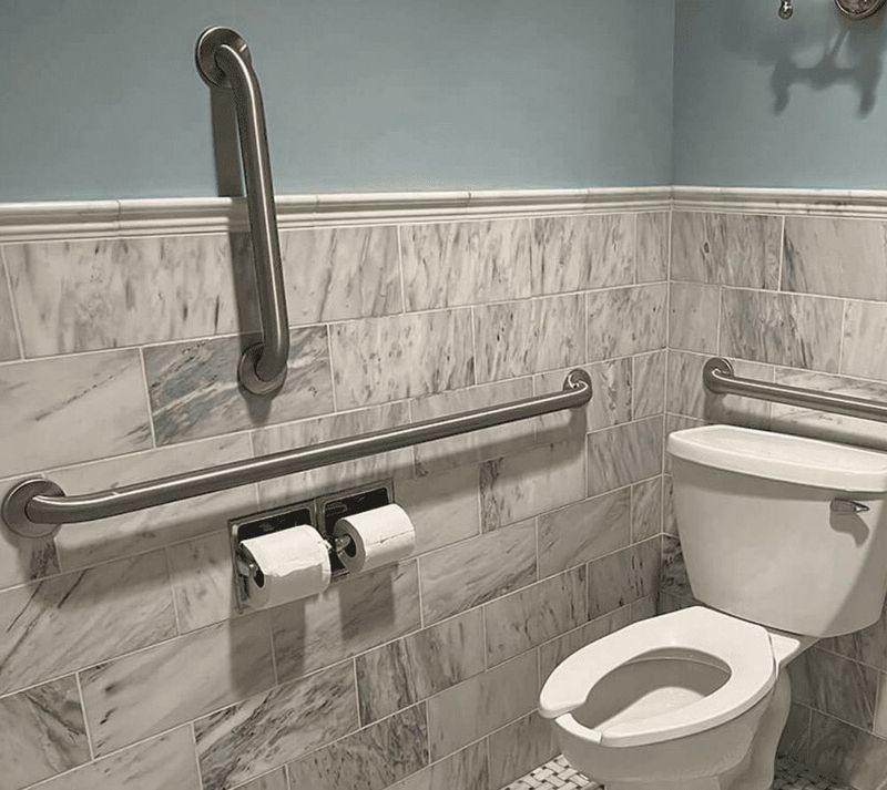 Brushed grab bars installed on marble tile