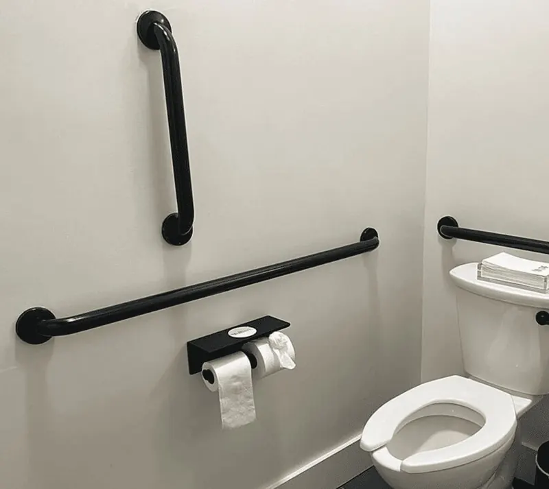 Matte black grab bars on light tile in a modern DFW bathroom