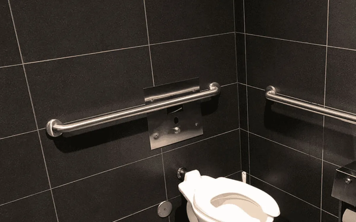 Brushed stainless grab bars professionally installed on dark tile in a DFW bathroom